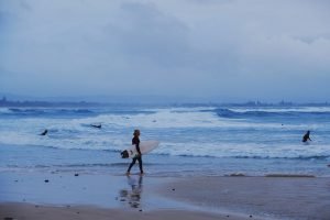 surfer walking to ocean in Byron Bay