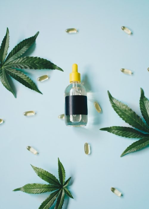 small bottle with cannabis leaves around it